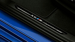 Накладки порогів з фірмовою емблемою «X5 M Competition».