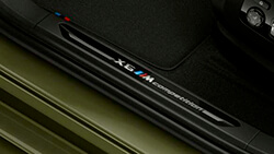 Накладки порогів з фірмовою емблемою «X6 M Competition».